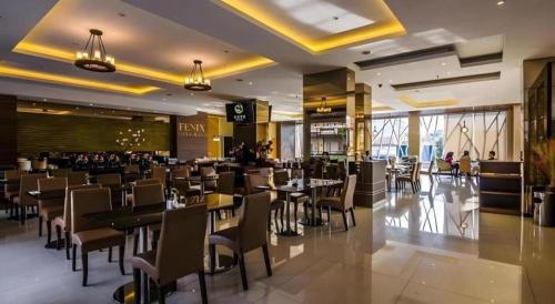 a dining room with tables and chairs in a restaurant at Gets Hotel Malang in Malang
