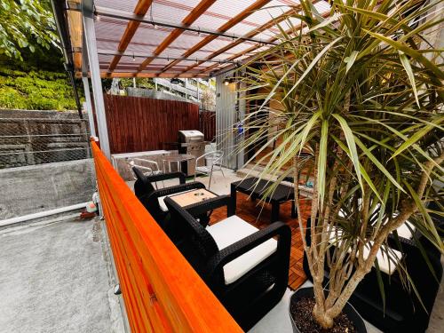a porch with chairs and a potted plant at Resort Villa 海結-umiyui- in Onna