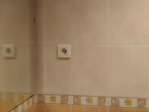 een witte tegelwand met een luidspreker erop bij Royal Denai View Syariah in Bukittinggi