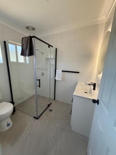 een badkamer met een douche, een toilet en een wastafel bij Mia Motel in Griffith