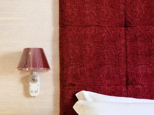 a red lamp on a wall next to a bed at Duomo Suites & Spa in Catania