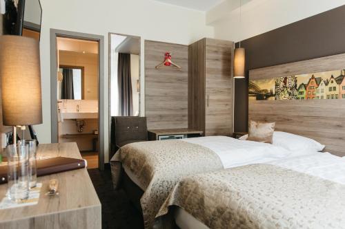 ein Hotelzimmer mit 2 Betten und einem Schreibtisch in der Unterkunft Hotel Sion in Köln