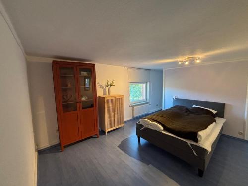 a bedroom with a bed and a cabinet in it at Pure nature - Dein Landhaus in Wardow