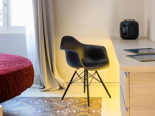 a black chair sitting next to a desk in a room at Duomo Suites & Spa in Catania
