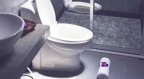 une salle de bains avec toilettes et lavabo dans l'établissement V Valley Resort, à Satun