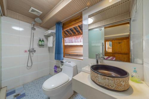 a bathroom with a toilet and a wooden sink at Travel & Rest Inn in Lijiang