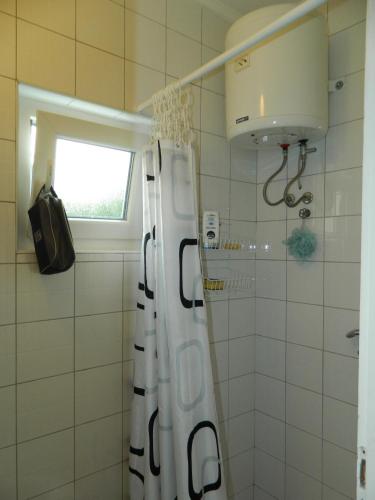 a bathroom with a shower curtain and a window at Vacation Home Katarina in Čapljina
