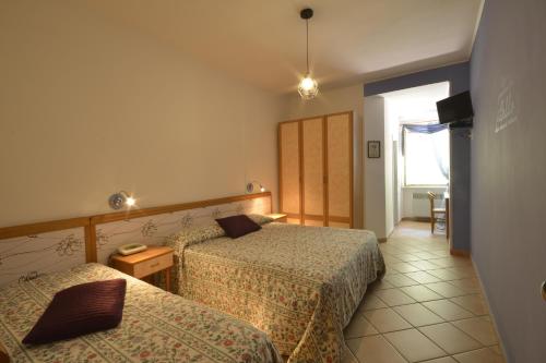 una camera d'albergo con due letti e un tavolo di Hotel Pineta Ristorante country house in Fabriano a Campodonico
