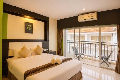 una camera da letto con un letto grande e un balcone di The Star House a Patong Beach