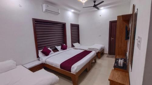 a bedroom with two beds and a ceiling fan at Prem villas homestay in Tājganj