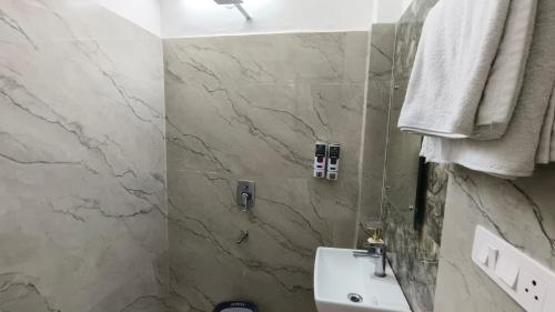 a bathroom with a sink and a marble wall at Prem villas homestay in Tājganj