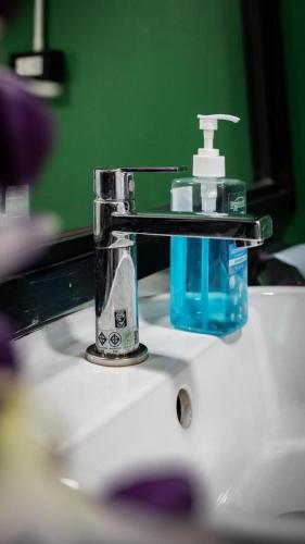 a bathroom sink with a bottle of soap on it at The Highdogs Hostel in Phi Phi Islands