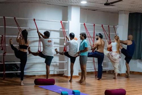 een groep mensen die pilates doen in een sportschool bij Vedic Hatha Vinyasa Yoga Ashram in Narendranagar