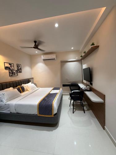 a bedroom with a bed and a desk and a television at Palukuri's Grand in Vizianagram City