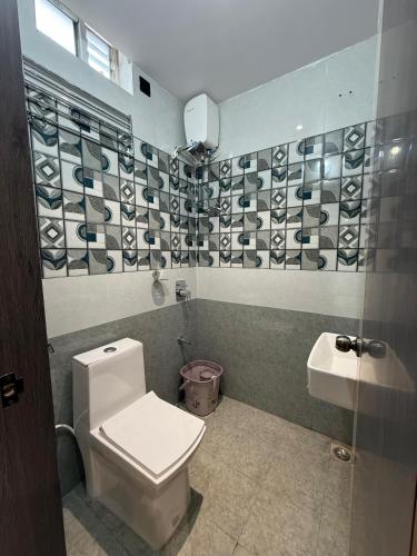 a bathroom with a toilet and a sink at Palukuri's Grand in Vizianagram City