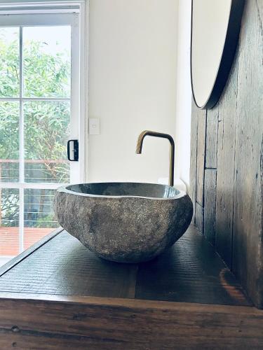 a large stone sink in a bathroom with a window at Secluded Villa with Lush Gardens, Spa and Fireplace in Mount Dandenong