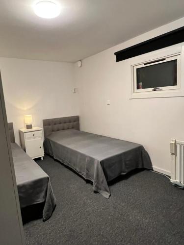 a bedroom with a bed and a window and a tv at Mini Hus in Märsta