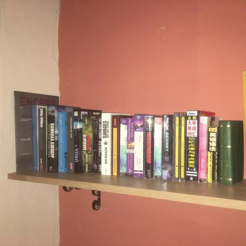 a row of books sitting on a shelf at For Rest Aparthotel in St Paul's Bay