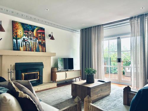 a living room with a couch and a fireplace at Secluded Villa with Lush Gardens, Spa and Fireplace in Mount Dandenong