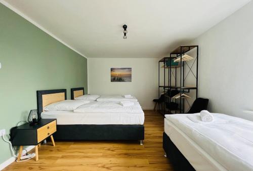 een slaapkamer met 2 bedden en een tafel en een plank bij Cozy, central, fully equipped in Essen in Essen