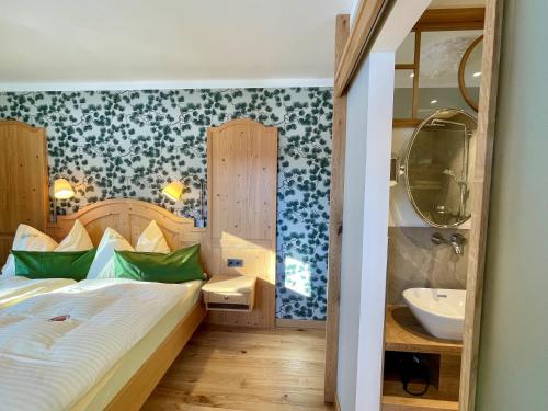 een slaapkamer met een bed en een wastafel bij Heutaler Hof - Hotel im Naturidyll in Unken