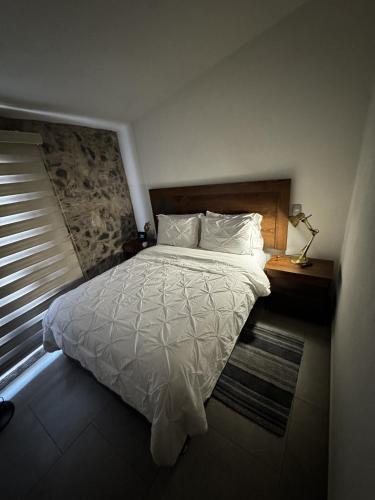 a bedroom with a white bed and a window at Sicilia con Terraza y chimenea in Santeagueda