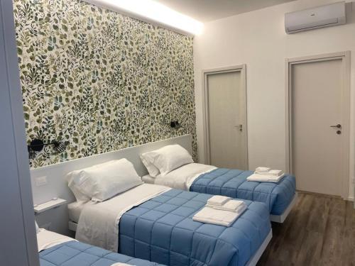 een slaapkamer met twee bedden en een muurschildering bij La Casa Sul Viale in Iesi