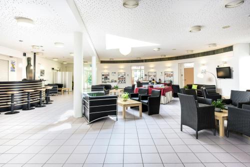 a restaurant with chairs and tables and a tv at CJD Bonn Castell in Bonn
