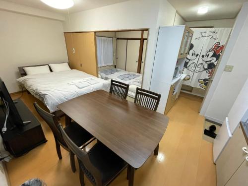 een kleine kamer met een tafel en een bed bij サムライ シティ イン 信夫屋 in Aizuwakamatsu