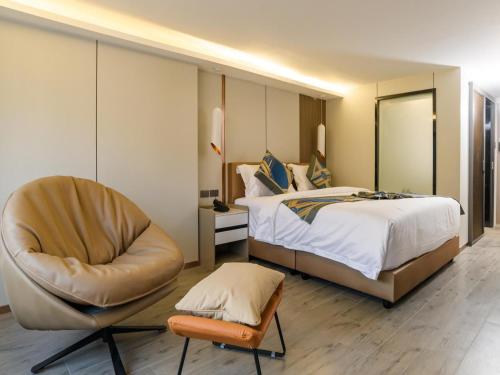 een hotelkamer met een bed en een stoel bij HuiKe MARITZTLE HOTEL in Ban Bang Toei (1)