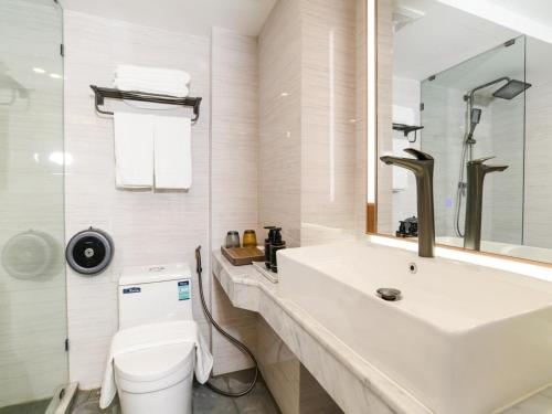 een badkamer met een wastafel, een toilet en een spiegel bij HuiKe MARITZTLE HOTEL in Ban Bang Toei (1)