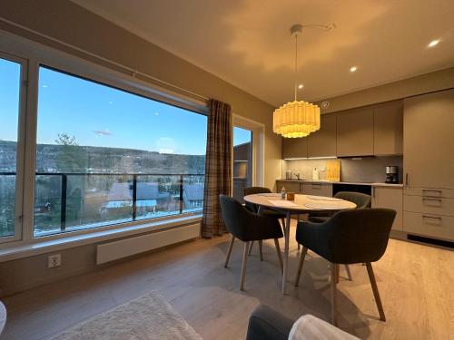 eine Küche mit Tisch und Stühlen und einem großen Fenster in der Unterkunft Motoppen Trysil Aparments in Trysil