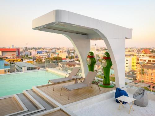 une terrasse sur le toit avec des chaises et une piscine dans l'établissement 酒店MARQUIS HOTEl, à Ban Bang Toei (1)