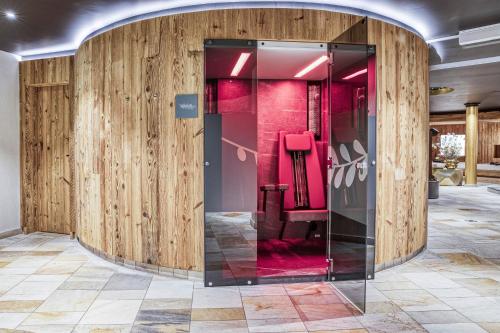 een glazen lift in een kamer met houten wanden bij Hotel Alte Post in Sankt Anton am Arlberg
