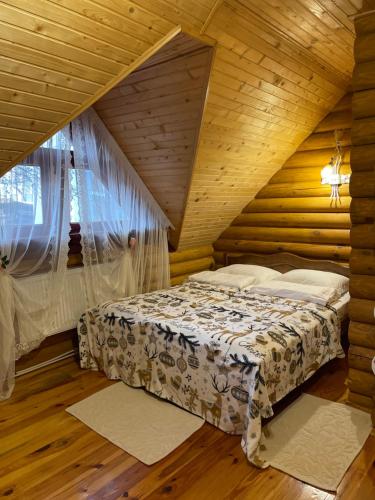 een slaapkamer met een bed in een houten kamer bij Еко котедж Яблуницька троянда in Yablunytsia