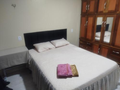 a bedroom with a large bed with a purple bag on it at Casa dois quartos 5 pessoas, no centro de Belém in Belém