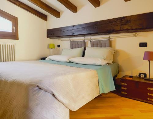 een slaapkamer met een groot bed met een houten hoofdeinde bij YAWHome B&B in Bologna