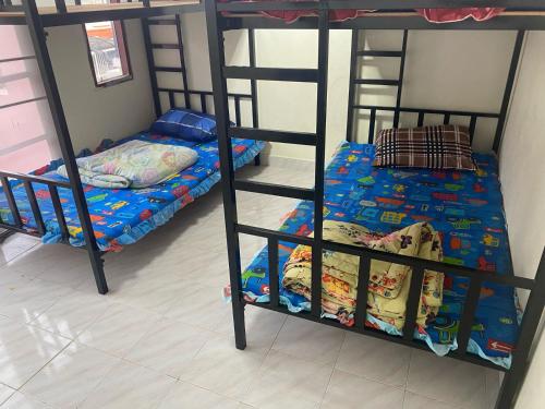 two bunk beds are in a room with at Royal Himalayan Hostel in Ban Phraek Sa