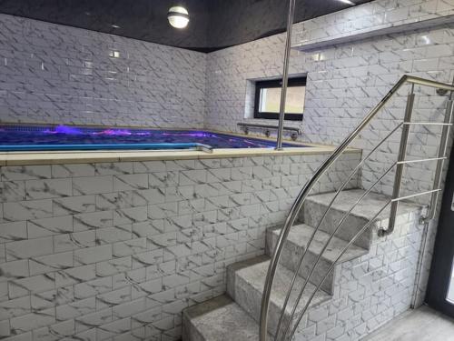 ein Badezimmer mit Treppe und ein Schwimmbad in der Unterkunft Pensiunea Dariana in Bucium-Sat