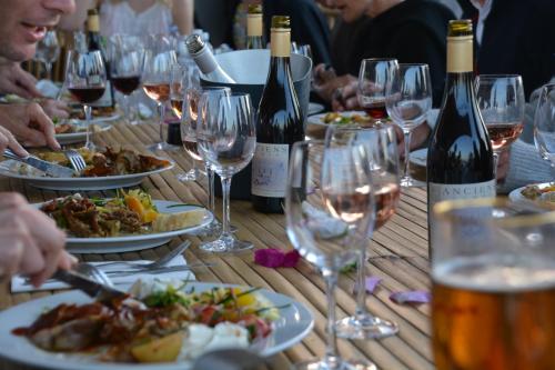 a wooden table with plates of food and wine glasses at Slite Strand resort in Slite