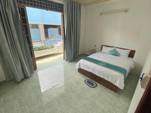 ein Schlafzimmer mit einem Bett und einem großen Fenster in der Unterkunft Khách sạn K-Trang APARTMENT in Cần Thơ