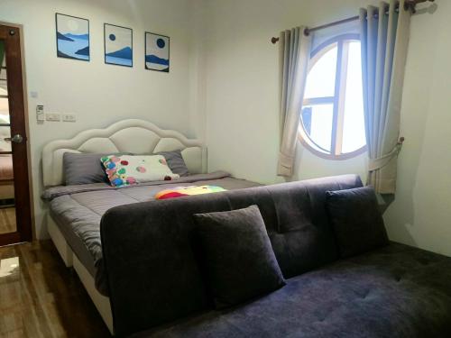 een slaapkamer met een bank en een raam bij มินิฮาร์ท เฮาส์บีช Mini Heart House Beach in Ban Chak Phai