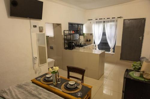a living room with a table and a kitchen at Thorne's crip in Pretoria