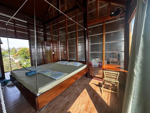 a bedroom with a bed and a chair in a room at The Rustic Tree Farm in Thôn An Thạnh