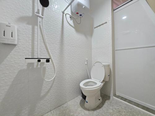 a white bathroom with a toilet and a shower at Anemos Resort By Tamastu in Pasirpogor