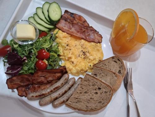 een bord ontbijt met eieren, worst en salade bij Apartmány Farní in Moravská Třebová