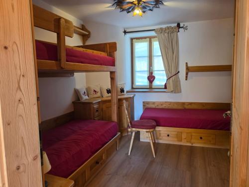 a bedroom with two bunk beds and a window at Meleres 11 in Cortina dʼAmpezzo