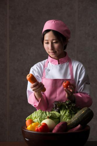 a young girl holding a carrot and a bowl of vegetables at Premier Hotel Mojiko in Kitakyushu