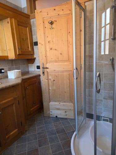 a bathroom with a shower and a tub at Meleres 11 in Cortina dʼAmpezzo