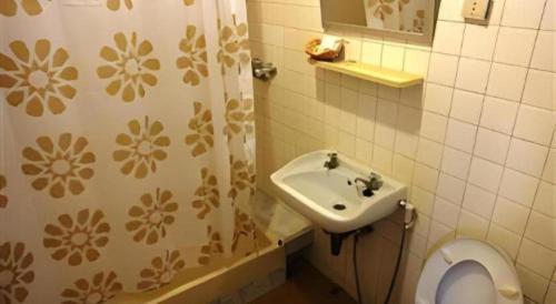 une salle de bains avec lavabo, toilettes et douche dans l'établissement Ubon Hotel, à Ubon Ratchathani